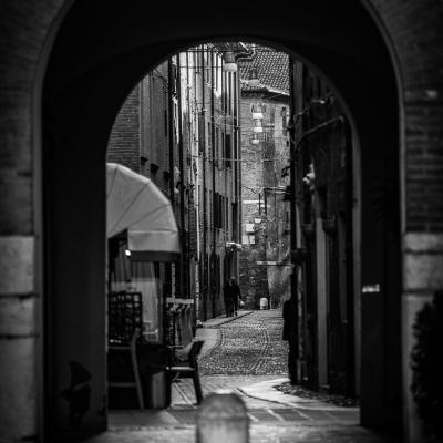 Black White Aufnahme einer Gasse druch einen Bogen fotografiert.