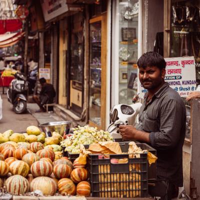 Gemüse auf einem Strassenmarkt in Indien wo viele Leute herumstehen