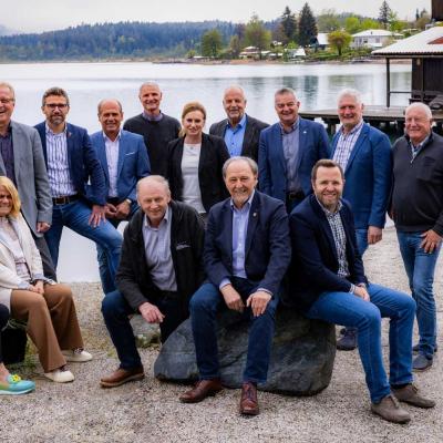 Gruppenfoto mit 15 Personen am Ufer eines Sees.